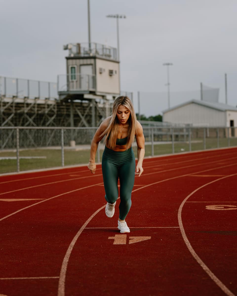 Athlete accelerating into a sprint on the track at dawn